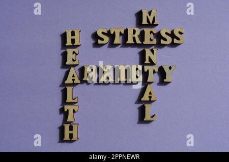 Mentale, Salute, Ansia, stress, parole in lettere di alfabeto di legno in forma di croce isolato sullo sfondo Foto Stock