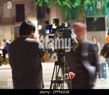 Spagna, Barcellona - 8 ottobre 2017: Ripresa del lavoro di operatore sulla strada con luce artificiale di notte, riprese notturne. Televisione e film amatoriali Foto Stock