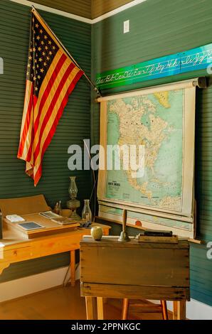 Una mappa è appesa al muro accanto a una bandiera americana presso la Little Red Schoolhouse di Baldwin County Bicentennial Park a Stockton, Alabama. Foto Stock