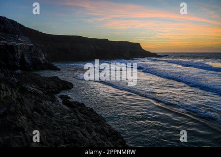 Tramonto sulle scogliere a sud di Puertito de los Molinos, un piccolo villaggio di pescatori sulla costa occidentale dell'isola di Fuerteventura nelle Isole Canarie, a. Foto Stock