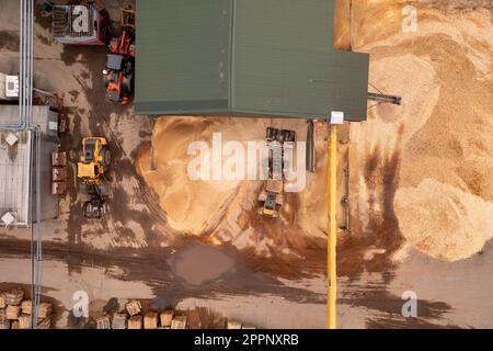 Riprese di droni di segheria, macchinari e trucioli durante il giorno estivo. Direttamente sopra Foto Stock