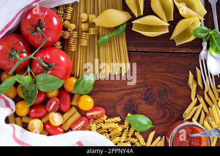 Sfondo di pasta di diversi tipi con pomodori e basilico vista superiore Foto Stock