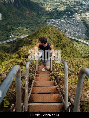 Uomo scalinata escursionistica al Cielo (scale Haiku) a Oahu, Hawaii. Foto di alta qualità. Guardando le scale. Foto Stock