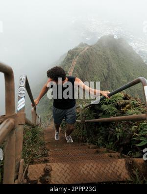 Uomo scalinata escursionistica al Cielo (scale Haiku) a Oahu, Hawaii. Foto di alta qualità. Guardando le scale. Foto Stock