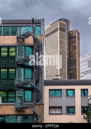 Francoforte, Germania - 29 gennaio 2023: Scale circolari esterne su un edificio e paesaggio urbano con grattacieli a Francoforte, Germania Foto Stock