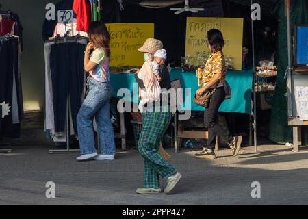 SAMUT PRAKAN, THAILANDIA, Apr 07 2023, Una donna porta un bambino per strada con chiosco Foto Stock