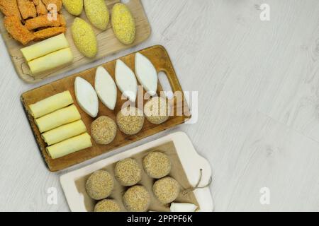 Semilavorati assortiti fatti in casa su boarde di legno. Cotolette surgelate, gnocchi, pepite. Preparazioni di cibo fatto in casa. Spazio di copia. Foto Stock