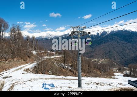 Contro il cielo blu e le montagne nella stazione sciistica Rosa Khutor a Sochi, Russia - 14 aprile 2023 Foto Stock