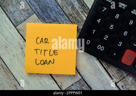 Concetto di titolo auto prestito scrivere su note appiccicose con calcolatrice isolata su tavolo di legno. Foto Stock