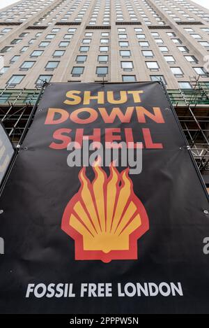 Londra, Regno Unito. 24 aprile 2023. Un grande banner che annuncia "Shut Down Shell" appare fuori dalla sede del colosso petrolifero Shell mentre gli attivisti del clima organizzano una "marcia per porre fine ai combustibili fossili" l'ultimo giorno delle proteste avviate dalla rivolta di estinzione e sostenute da più di 200 organizzazioni, tra cui gruppi ambientali, ONG e sindacati. Per affrontare l'emergenza climatica, chiedono al governo di interrompere le licenze, il finanziamento e l'approvazione di nuovi progetti sui combustibili fossili e di creare "assemblee cittadine" per affrontare la crisi climatica. Credit: Ron Fassbender/Alamy Live News. Foto Stock