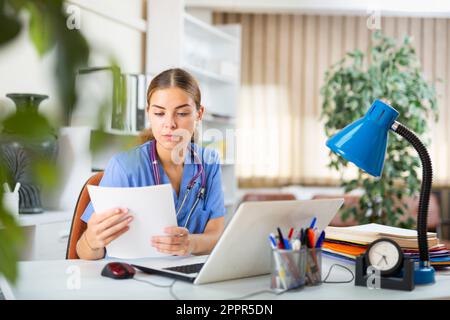 Giovane dottore femminile che lavora nel suo ufficio Foto Stock