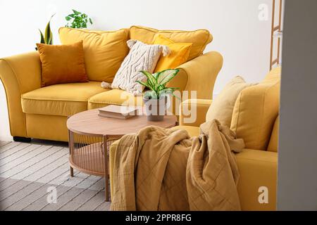 Interno di un elegante soggiorno con divano accogliente, poltrona e tavolino da caffè Foto Stock