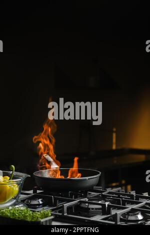 Aprire e controllare il fuoco in una padella Foto Stock