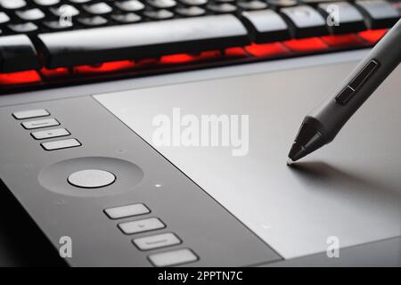 Tavoletta grafica con penna sulla superficie del dispositivo, foto ravvicinata. Strumento professionale per illustratori, designer, retouchers. Foto Stock