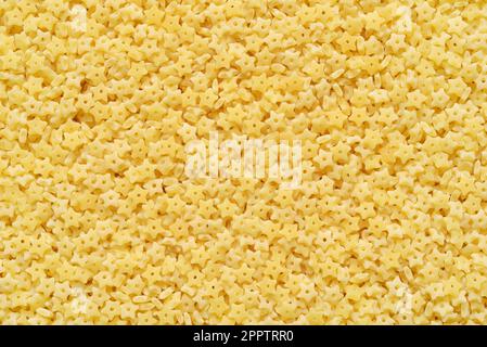 Piccola pasta stellina a forma di stella per la consistenza o lo sfondo della zuppa. Foto Stock