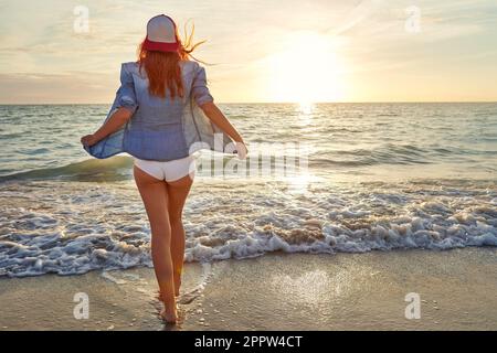 La chiamata del mare. Ha girato una giovane donna attraente godendosi una giornata alla spiaggia. Foto Stock