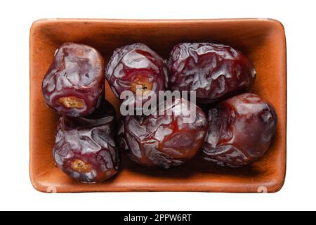 Datteri asciutti in ciotola di argilla isolato su bianco piatto vista stay Foto Stock