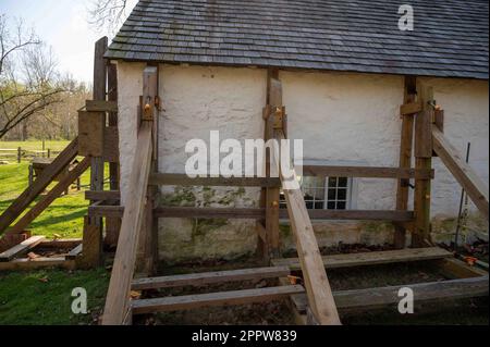 Sostegno in legno ponteggi rinforzi danneggiati cottage coloniale Foto Stock