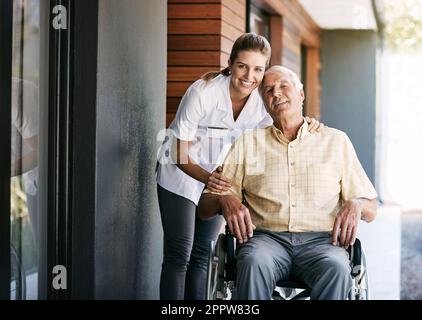 Sforzandosi di fornire un'assistenza di qualità a tutti i suoi pazienti. Ritratto di un'infermiera che si occupa di un paziente anziano su una sedia a rotelle al di fuori di una casa di riposo. Foto Stock