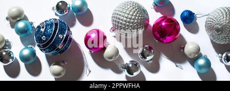 Albero di Natale baubles, composizione di tendenza festosa con luce dura e ombre su sfondo bianco, banner. Natale, Capodanno vacanze minimo creati Foto Stock