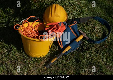 lavori nei cantieri edili, protezione individuale di casco, martello e guanti simbolo del lavoro, falegnami e operai nei cantieri edili. superbonus Foto Stock