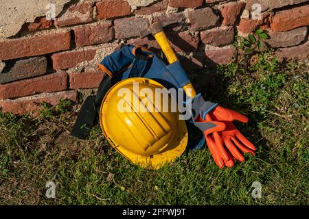 lavori nei cantieri edili, protezione individuale di casco, martello e guanti simbolo del lavoro, falegnami e operai nei cantieri edili. superbonus Foto Stock