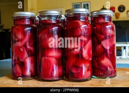 Le pere sono imbottigliate sotto vuoto in vino rosso, con zenzero, chiodi di garofano e cannella Foto Stock