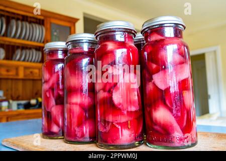 Le pere sono imbottigliate sotto vuoto in vino rosso, con zenzero, chiodi di garofano e cannella Foto Stock