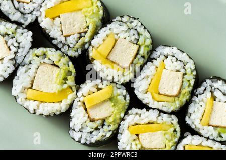 Sushi vegano con tofu, avocado e mango. Cibo sano Foto Stock