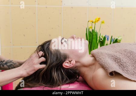 Massaggio alla testa. Procedure del salone per la cura dei capelli, rilassamento. Il paziente riceve un massaggio alla testa. Foto Stock