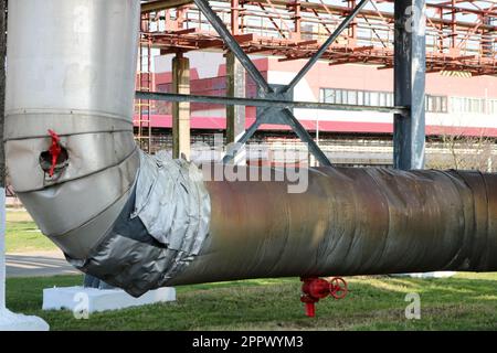 Estocad pipeline, grande tubo di vapore in isolamento in fibra di vetro con ventrali rossi, raccordi, valvole, drenaggio con travi blu in raffineria di petrolio, PET Foto Stock