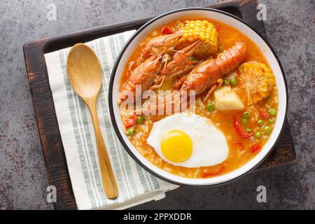 Zuppa di gamberi con pomodori, mais, pepe, patate e uova in un recipiente sul tavolo. Vista orizzontale dall'alto Foto Stock