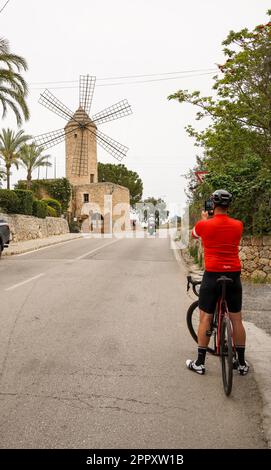 Mallorca, Spagna. Cycler che fa foto al vecchio mulino a vento di Maiorca, Santa Maria del Cami, ristorante, Isole Baleari, Spagna. Foto Stock