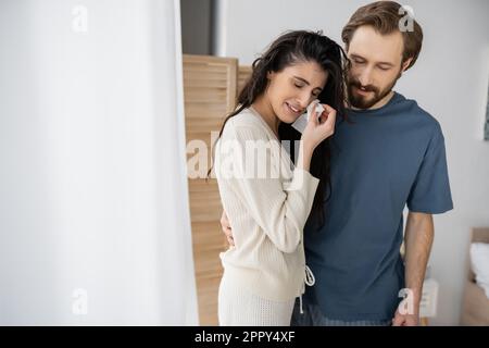 Barbuto uomo abbracciando e calmando ragazza piangente a casa, immagine stock Foto Stock