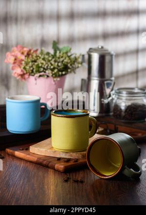 Tazze da caffè su un tavolo di legno in un ambiente rustico Foto Stock