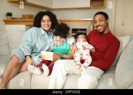 Ritratto di famiglia interrazziale felice con due bambini piccoli Foto Stock