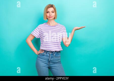 Foto di bella ragazza bella bob hairstyle a righe braccio t-shirt dimostrare offrire spazio vuoto isolato su sfondo di colore turchese Foto Stock