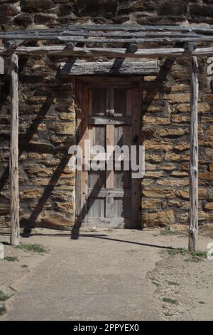 Una porta in legno vintage situata nella parete di mattoni di Mission San Jose a San Antonio, Texas Foto Stock