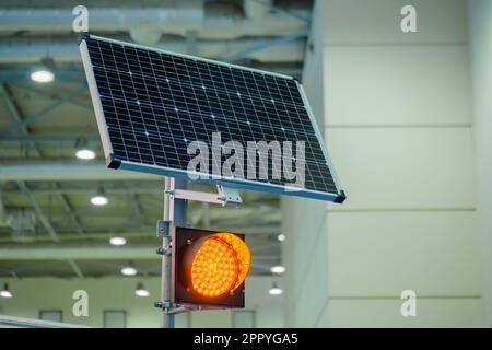 Semaforo a LED singolo arancione alimentato da pannelli solari in mostra - primo piano Foto Stock