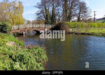 Ponte ad arco di mattoni rossi con ringhiera metallica sul fiume Avon (Bristol Avon) a Upper Woodford vicino Salisbury nel sud dell'Inghilterra, Regno Unito Foto Stock