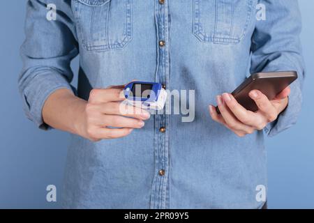 Donna che esegue l'autotest per i livelli di ossigeno nel sangue dal pulsossimetro Foto Stock