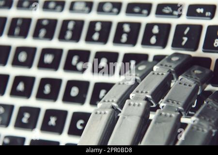 Mano di un robot mentre si lavora su una tastiera di un computer , spazio per il testo . Foto Stock