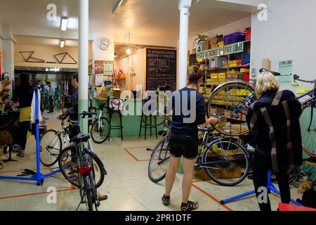 Persone che lavorano su biciclette a la Cycklette, 70 Rue du Chemin Vert, Parigi, Francia. Una cooperativa di biciclette autoriparanti a basso costo di la Petite Rockette. Foto Stock