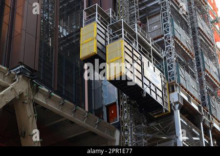 Un paranco Raxtar per lo spostamento di persone e materiali in un cantiere di New York City. Gli ascensori utilizzano un sistema di trasmissione a pignone e cremagliera. Foto Stock