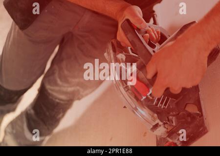 Uomo in azione al lavoro con strumenti potenti. Il falegname leviga una superficie di legno. Le vecchie fresatrici non vengono più utilizzate. Foto Stock