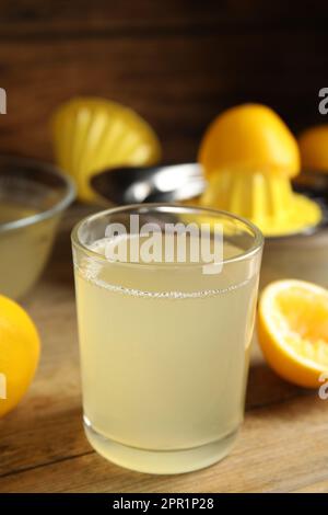 Succo di limone appena spremuto su un tavolo di legno Foto Stock