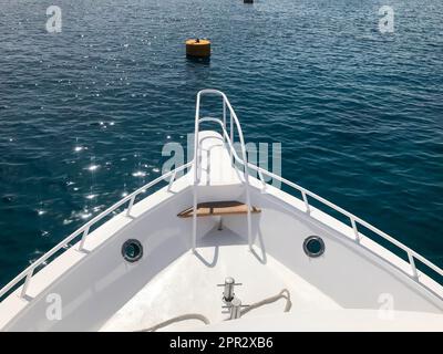 Lo stelo, la parte anteriore, la prua della nave, la barca, il battello da crociera sullo sfondo e le boe nel resort tropicale con acqua blu mare e co Foto Stock