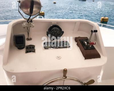 Cabina del capitano sulla nave, barca, nave da crociera con un volante, cruscotto, navigatore, contagiri e dispositivi di controllo sullo sfondo di Foto Stock