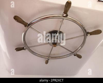 Volante lucido in acciaio inossidabile cromato nella cabina del capitano per il controllo su nave, barca, nave da crociera. Foto Stock