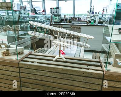 modello di aereo in legno. trasporto aereo da materiali improvvisati. un aeroplano con grandi ali si erge su un piedistallo di legno. Foto Stock